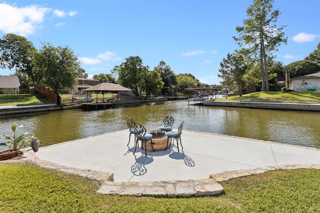 dock area featuring a gazebo, a fire pit, a water view, a patio area, and a lawn