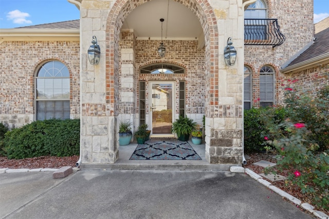 view of exterior entry with a balcony