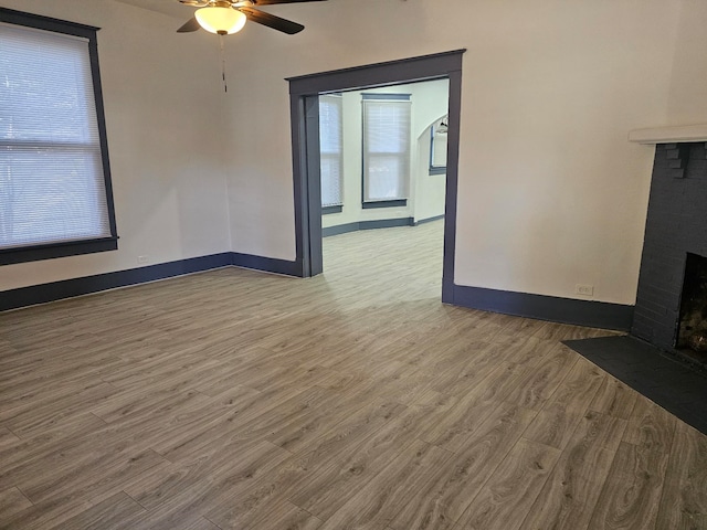 unfurnished living room with wood-type flooring and ceiling fan