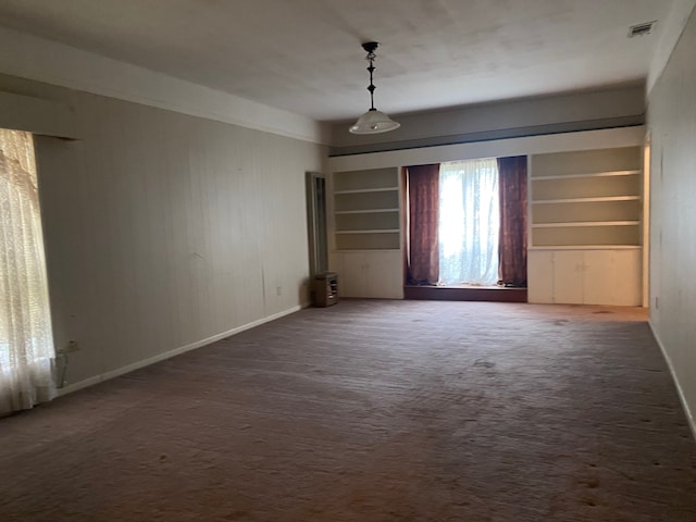 unfurnished room featuring built in features and carpet