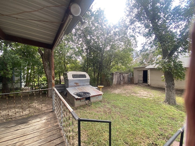 view of yard with an outdoor fire pit, a deck, and a shed