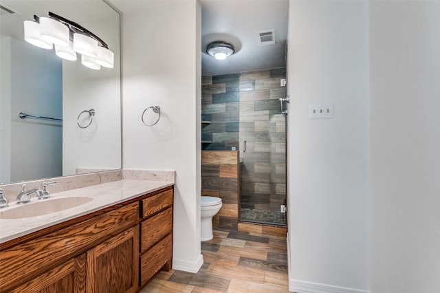 bathroom featuring vanity, toilet, a shower with door, and hardwood / wood-style floors