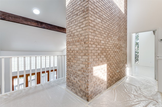 hall featuring beam ceiling, high vaulted ceiling, and light colored carpet