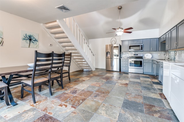 kitchen featuring appliances with stainless steel finishes, ceiling fan, sink, and backsplash