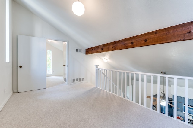 hallway featuring vaulted ceiling and light colored carpet