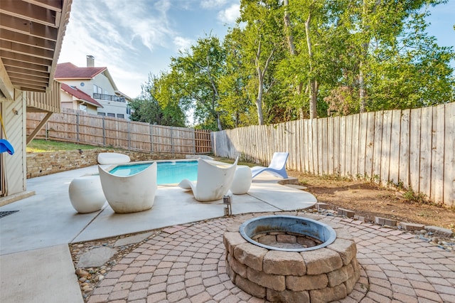 view of patio / terrace with an outdoor fire pit and a fenced in pool