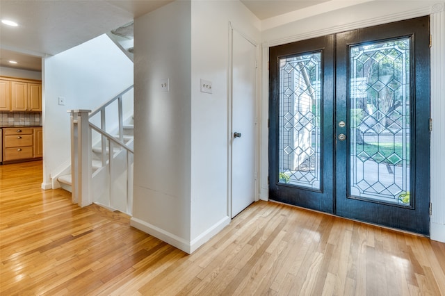 foyer entrance featuring light hardwood / wood-style flooring and french doors