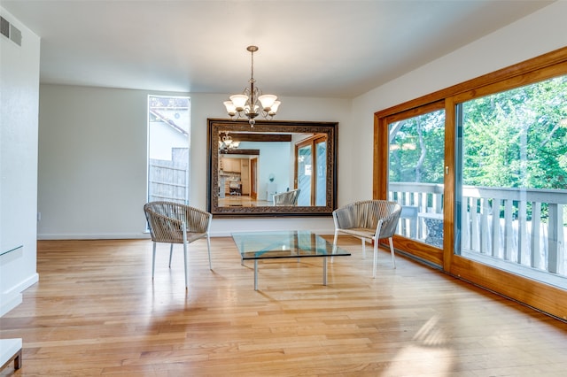 living area with light hardwood / wood-style floors and a notable chandelier