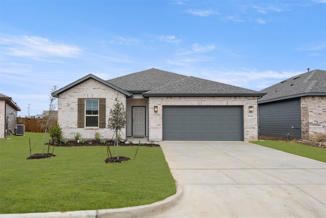 view of front of home featuring a garage, central AC, and a front yard