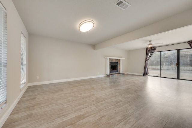 unfurnished living room with a fireplace, light wood-type flooring, and ceiling fan