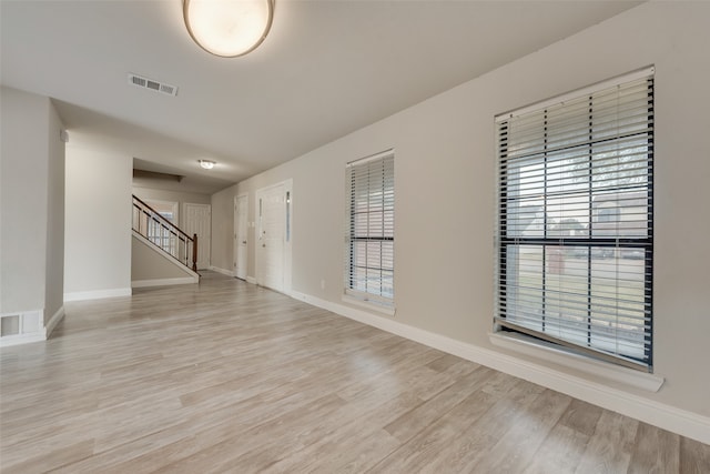 unfurnished room featuring light wood-type flooring and a wealth of natural light