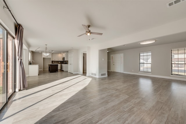 unfurnished living room with ceiling fan and hardwood / wood-style flooring