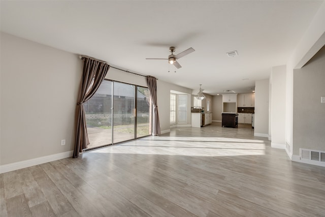 unfurnished living room with light hardwood / wood-style flooring and ceiling fan