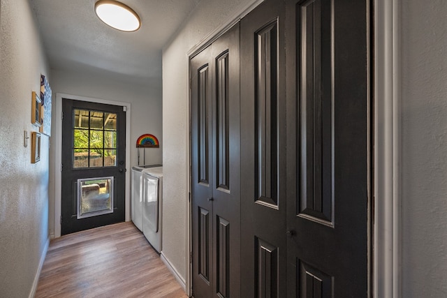 doorway featuring independent washer and dryer and light hardwood / wood-style floors