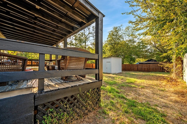 wooden deck with a storage shed and a yard