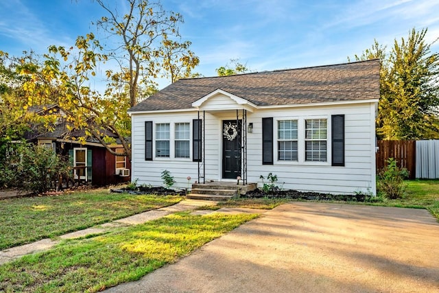 504 E Monterey St, Denison, TX 75021 - bungalow featuring roof with shingles, a front lawn, and fence