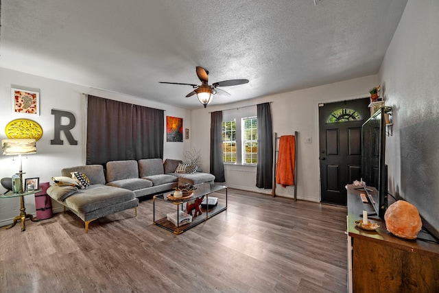 living room featuring a textured ceiling, hardwood / wood-style flooring, and ceiling fan