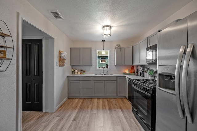 504 E Monterey St, Denison, TX 75021 - kitchen featuring black gas range, stainless steel fridge with ice dispenser, gray cabinetry, and a sink