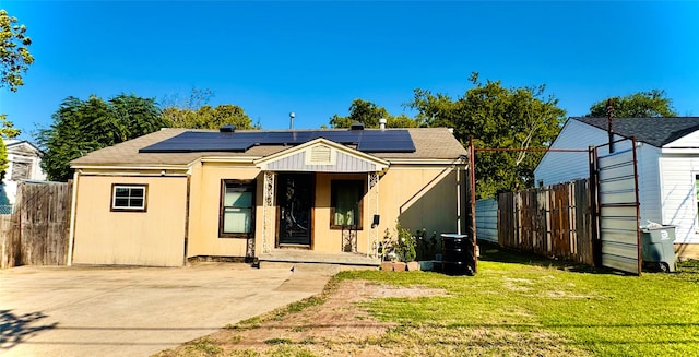 back of property with a patio area, solar panels, and a lawn