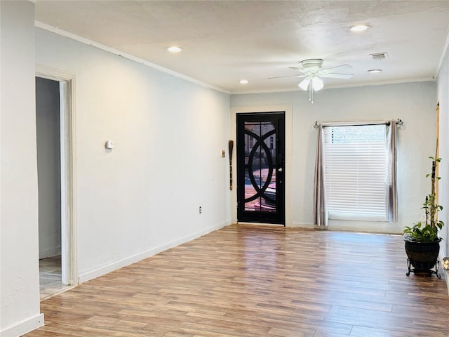 foyer with ornamental molding, light hardwood / wood-style flooring, and ceiling fan