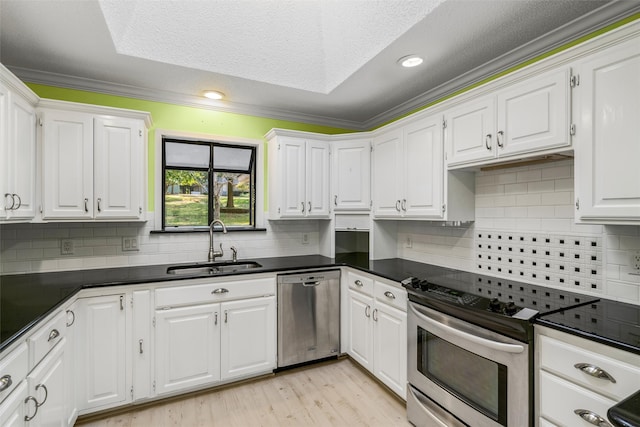 kitchen with crown molding, appliances with stainless steel finishes, and white cabinets