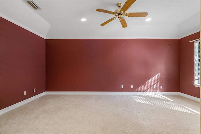 carpeted empty room with crown molding, a textured ceiling, vaulted ceiling, and ceiling fan