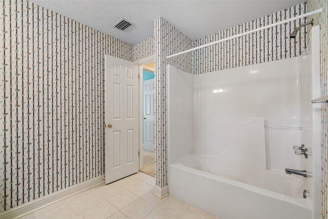 bathroom with tile patterned floors, a textured ceiling, and shower / washtub combination