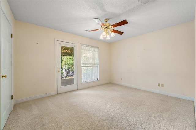 carpeted spare room featuring a textured ceiling and ceiling fan