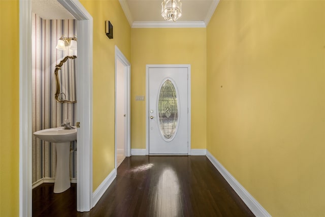 entrance foyer with a notable chandelier, ornamental molding, and dark hardwood / wood-style floors