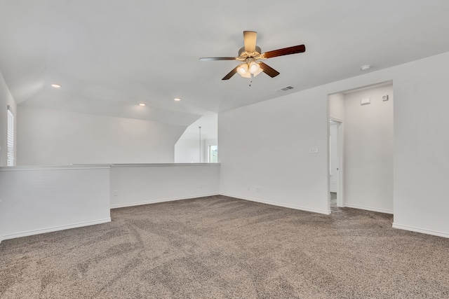 carpeted empty room with a wealth of natural light, vaulted ceiling, and ceiling fan