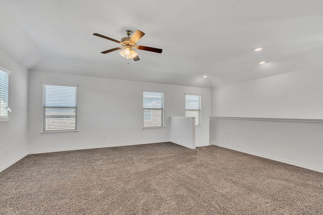 carpeted spare room with vaulted ceiling and ceiling fan