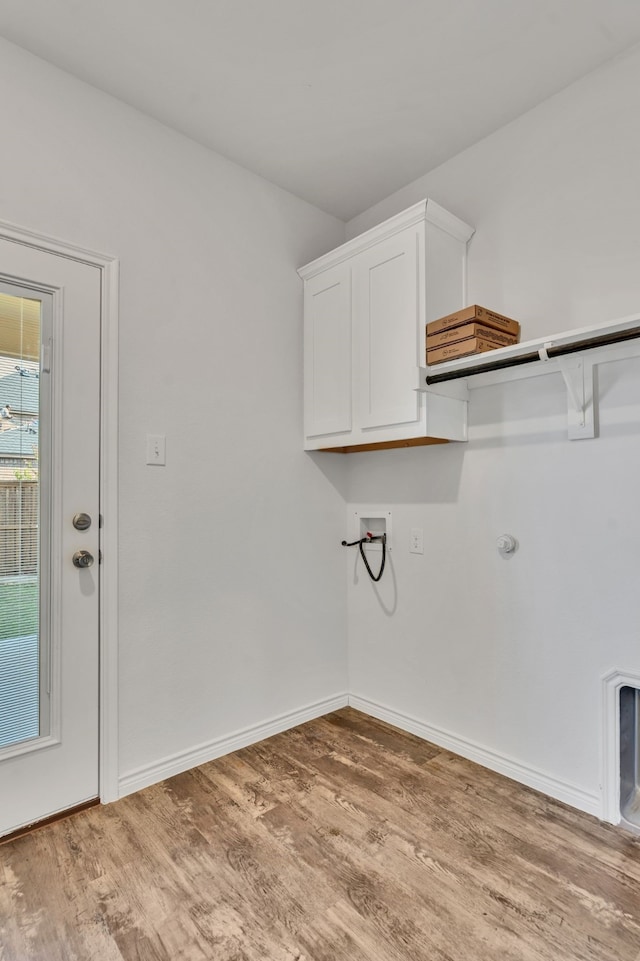 washroom with cabinets, washer hookup, and wood-type flooring