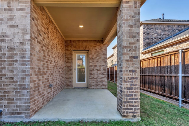 view of exterior entry with a patio