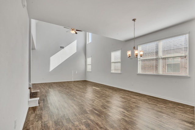 unfurnished living room with dark hardwood / wood-style floors and ceiling fan with notable chandelier