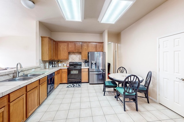 kitchen with sink, black appliances, and tasteful backsplash