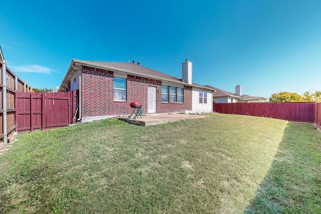 back of house with a patio and a lawn