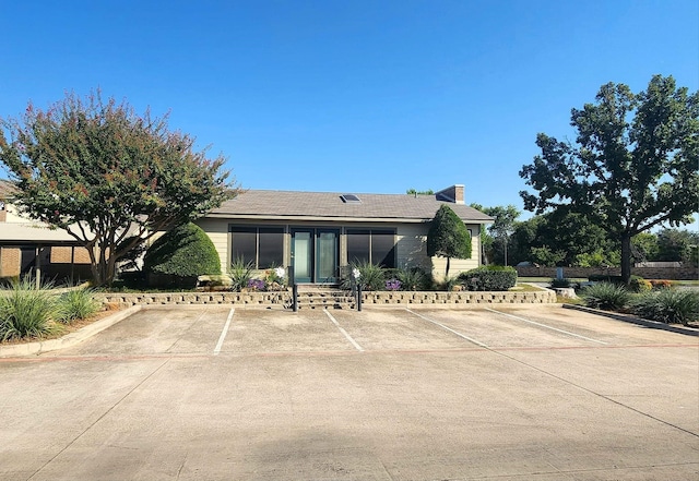 view of front of home featuring uncovered parking and a chimney