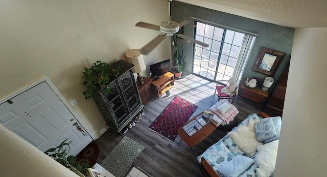 living room featuring a textured ceiling, ceiling fan, and wood finished floors