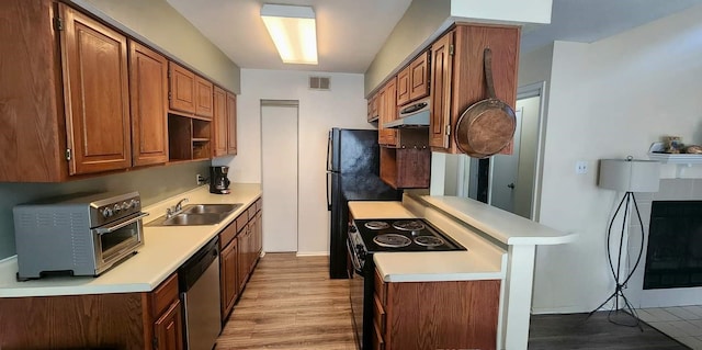 344 W Harwood Rd Unit A, Hurst, TX 76054 - kitchen featuring a sink, black appliances, light countertops, extractor fan, and a peninsula