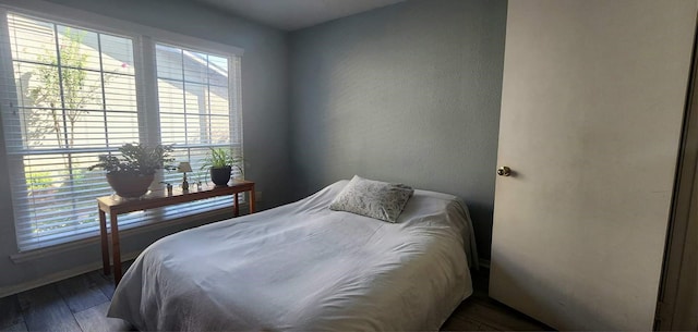 bedroom featuring multiple windows and dark wood finished floors