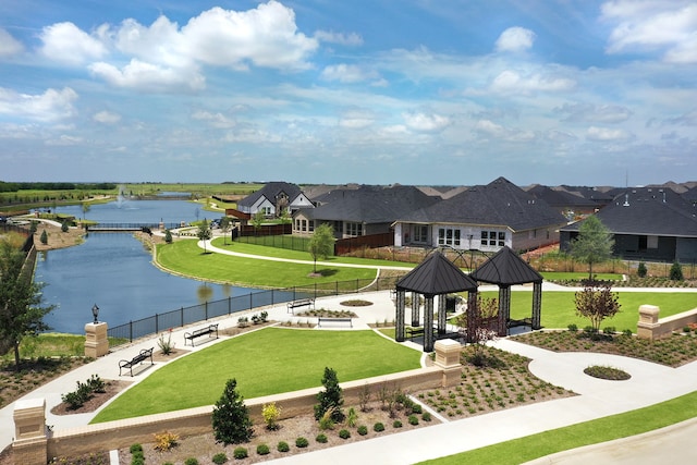 surrounding community with a water view, a gazebo, and a lawn