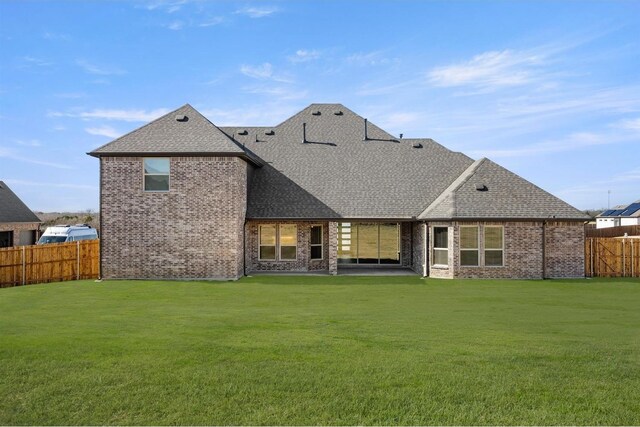 rear view of house featuring a lawn