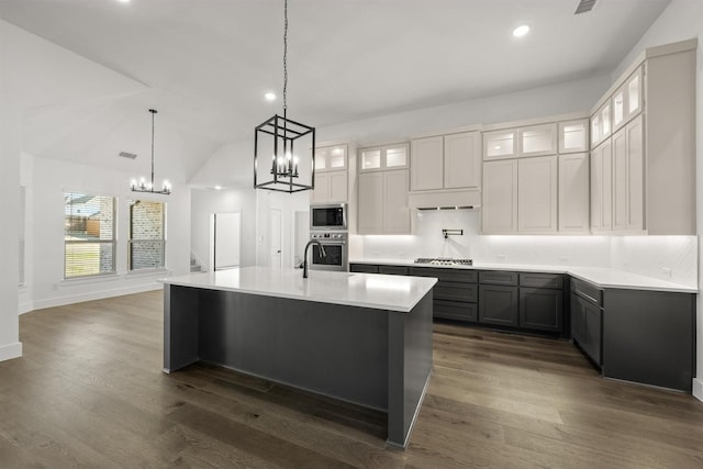 kitchen with white cabinets, stainless steel appliances, dark hardwood / wood-style floors, a large island, and a chandelier