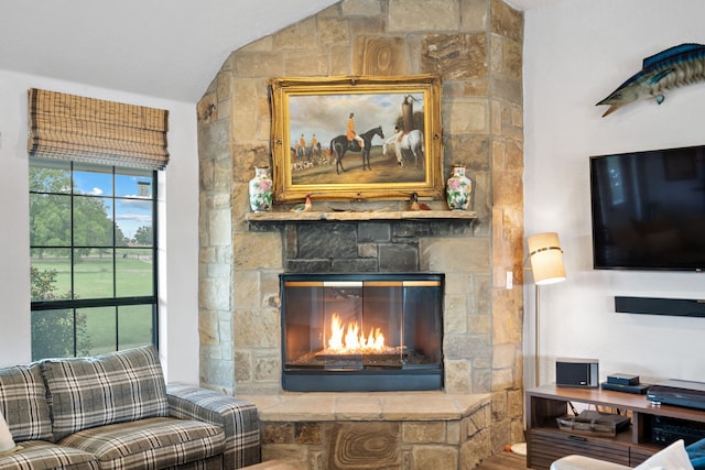 living room featuring vaulted ceiling, a fireplace, and hardwood / wood-style floors