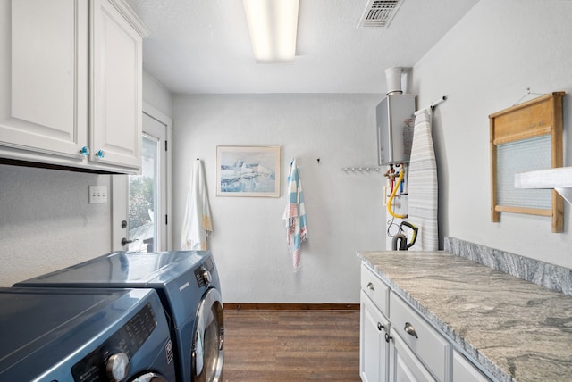 laundry room with cabinets, independent washer and dryer, tankless water heater, and dark hardwood / wood-style flooring