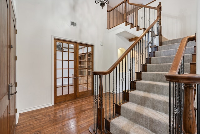 entrance foyer featuring french doors, hardwood / wood-style floors, and a high ceiling