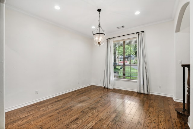 spare room with crown molding, a notable chandelier, and dark hardwood / wood-style floors