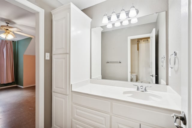 bathroom featuring vanity, toilet, hardwood / wood-style flooring, and ceiling fan