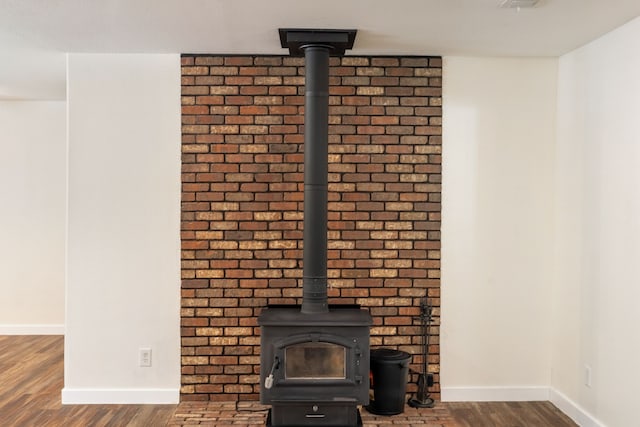 interior details featuring a wood stove and wood-type flooring