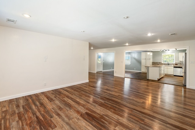 unfurnished living room with sink and dark hardwood / wood-style flooring